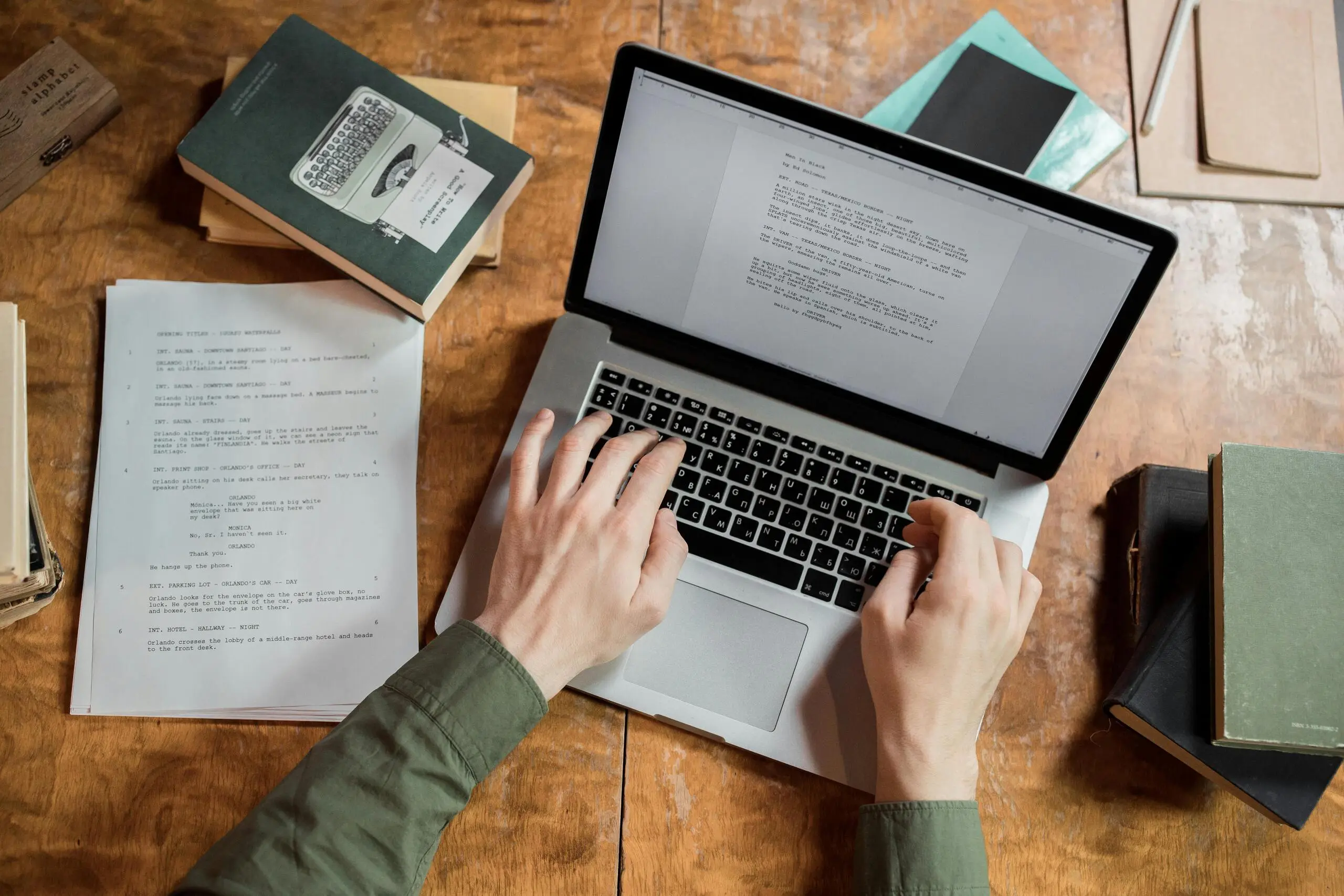 Rédacteur web SEO travaillant sur son ordinateur portable à partir de notes et de documents